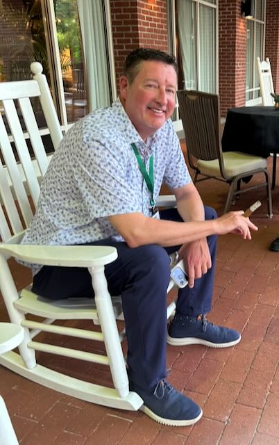 A guest relaxing with a cigar on a covered patio
