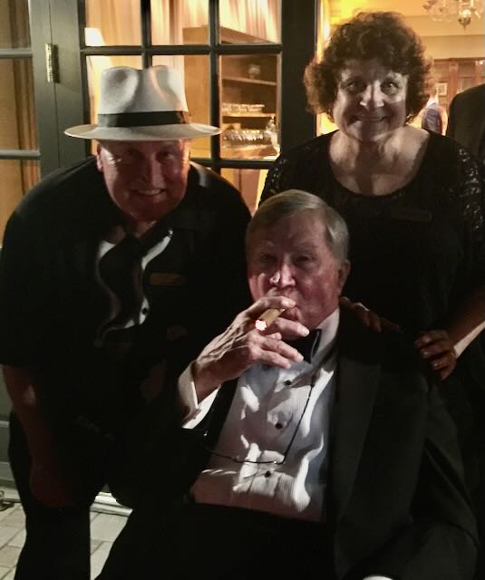 A guest savoring a cigar in black tie at an evening event