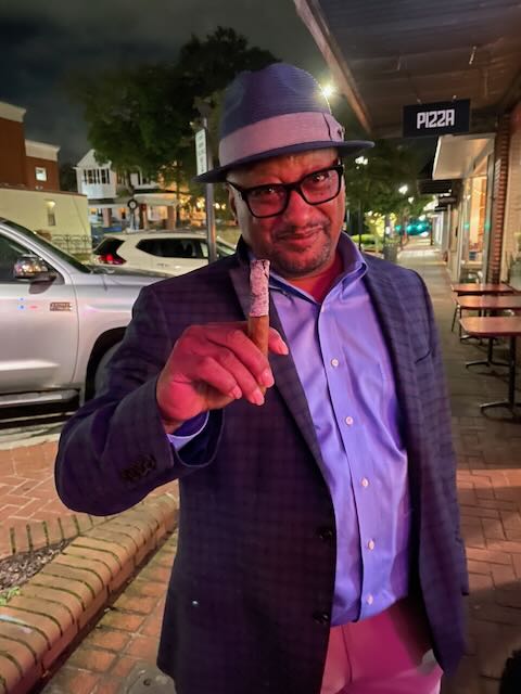 A guest holding one of Joe's cigars on the street after an evening event