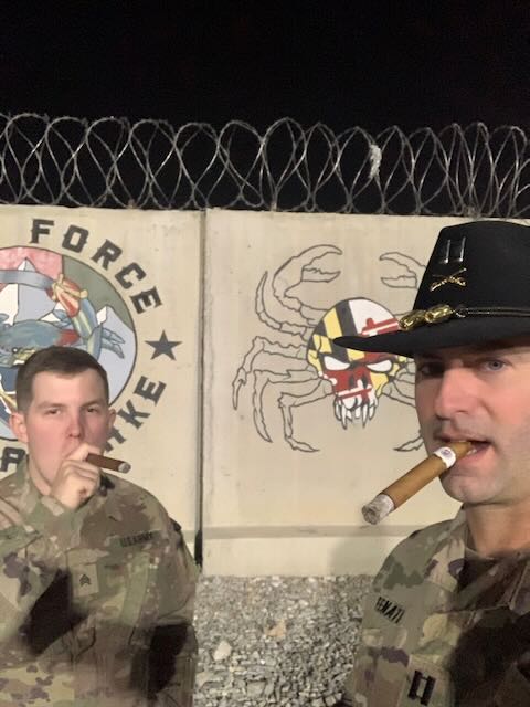 Two service members sharing a cigar overseas