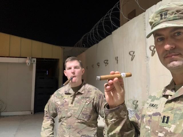Two service members enjoying cigars together