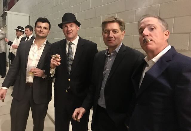 A group of guests enjoying cigars together at an evening event