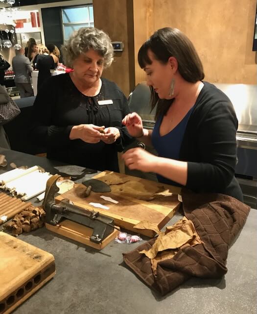 Guests learning the craft of hand-rolling at the tobacco table