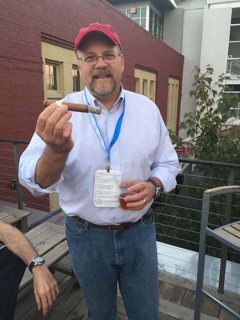 A guest enjoying a cigar and a drink outdoors