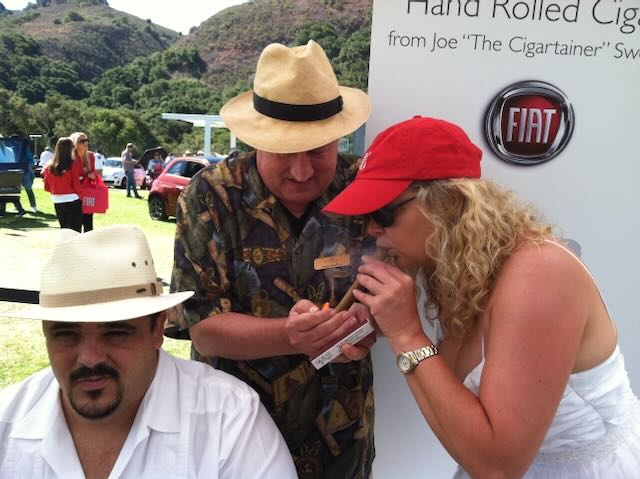 Joe lighting a cigar for a guest at an outdoor event