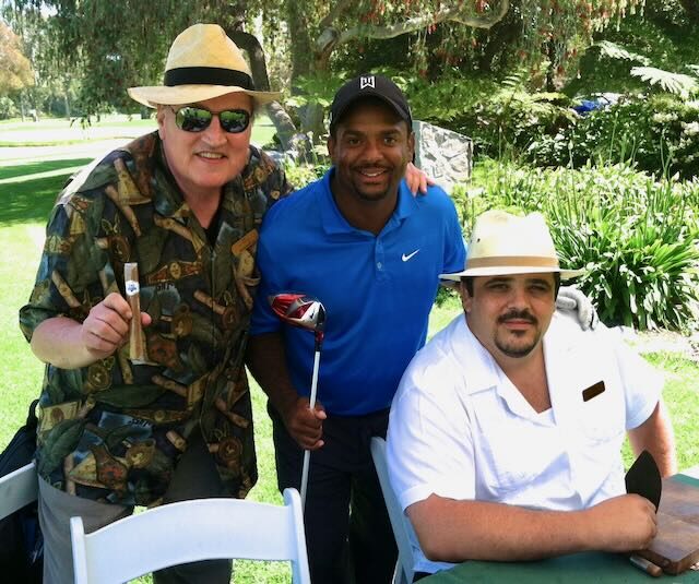 Joe and golfers with cigars by the fireplace