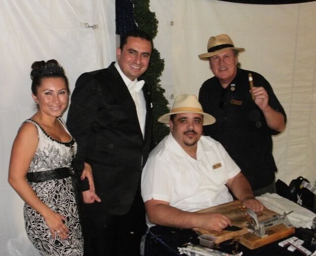 Joe and guests celebrating with cigars at an evening wedding reception